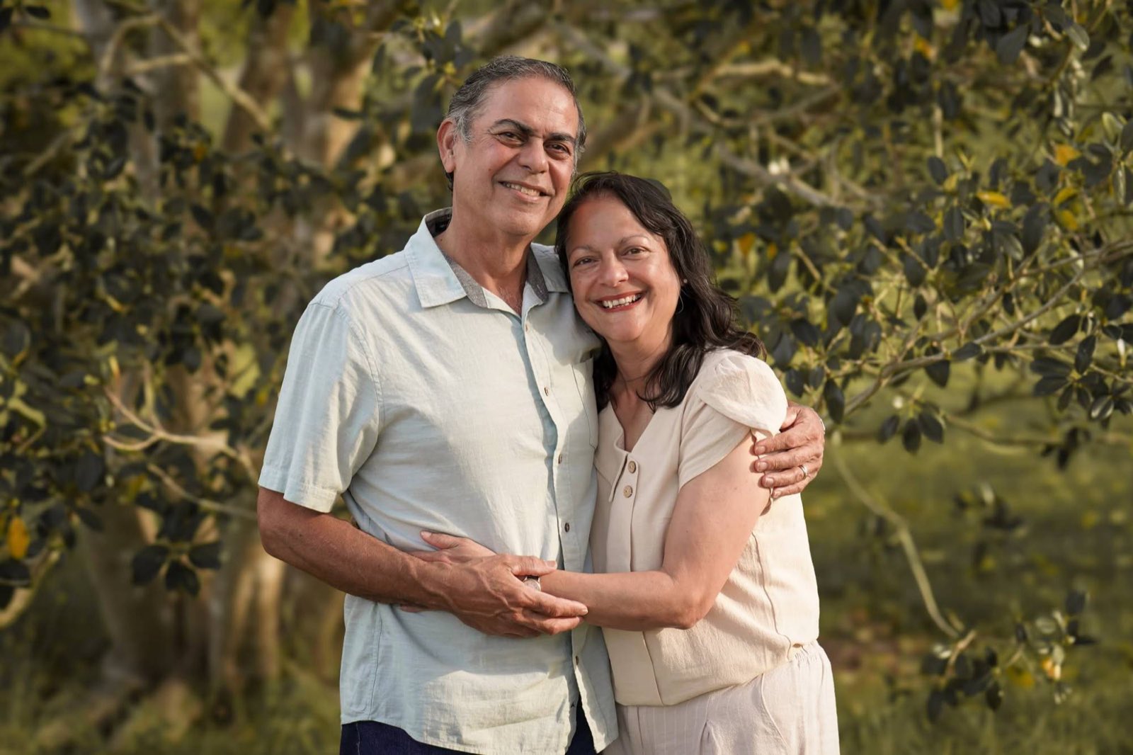 A couple sharing a warm hug in golden afternoon light at the park